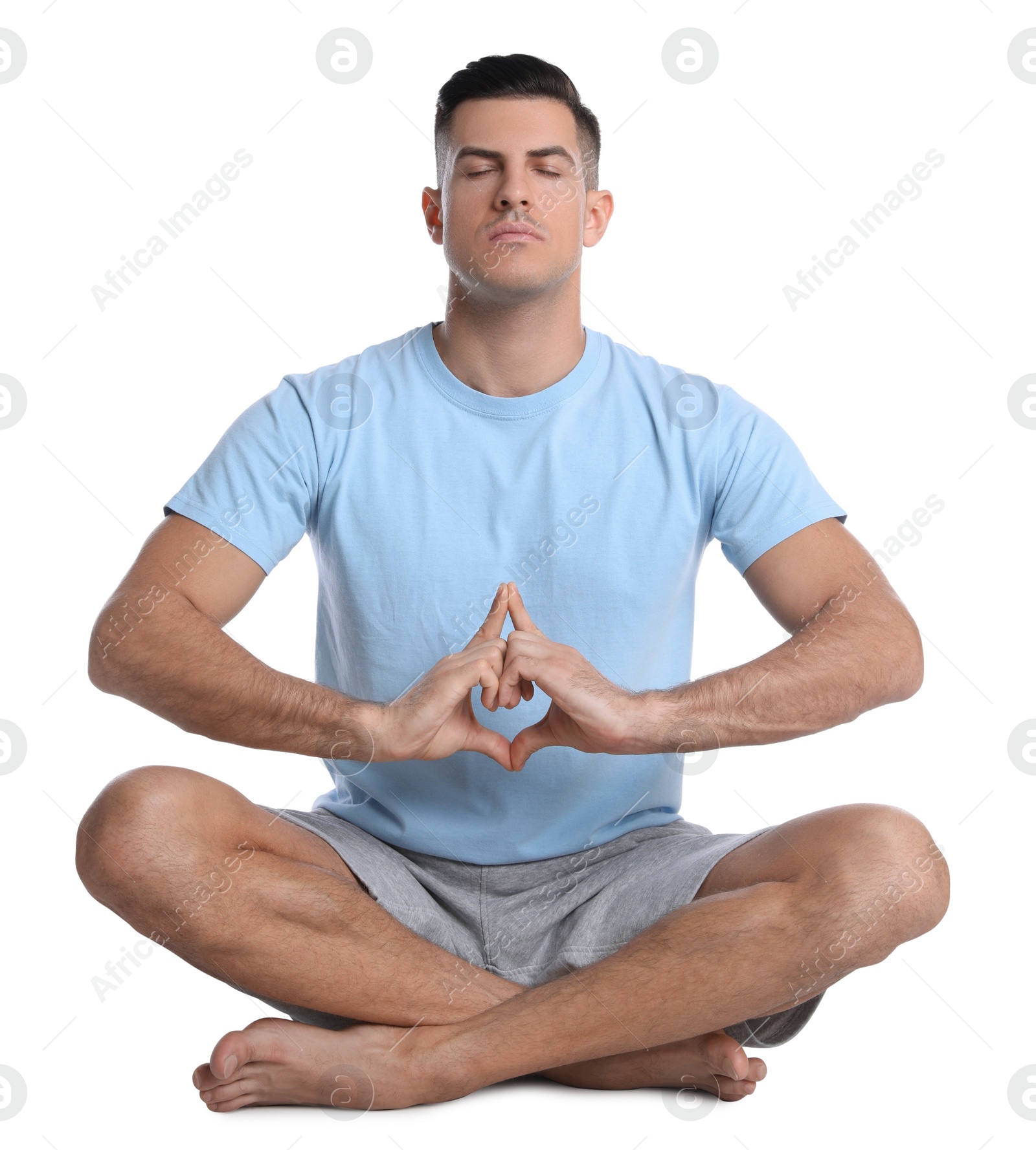 Photo of Handsome man meditating on white background. Harmony and zen