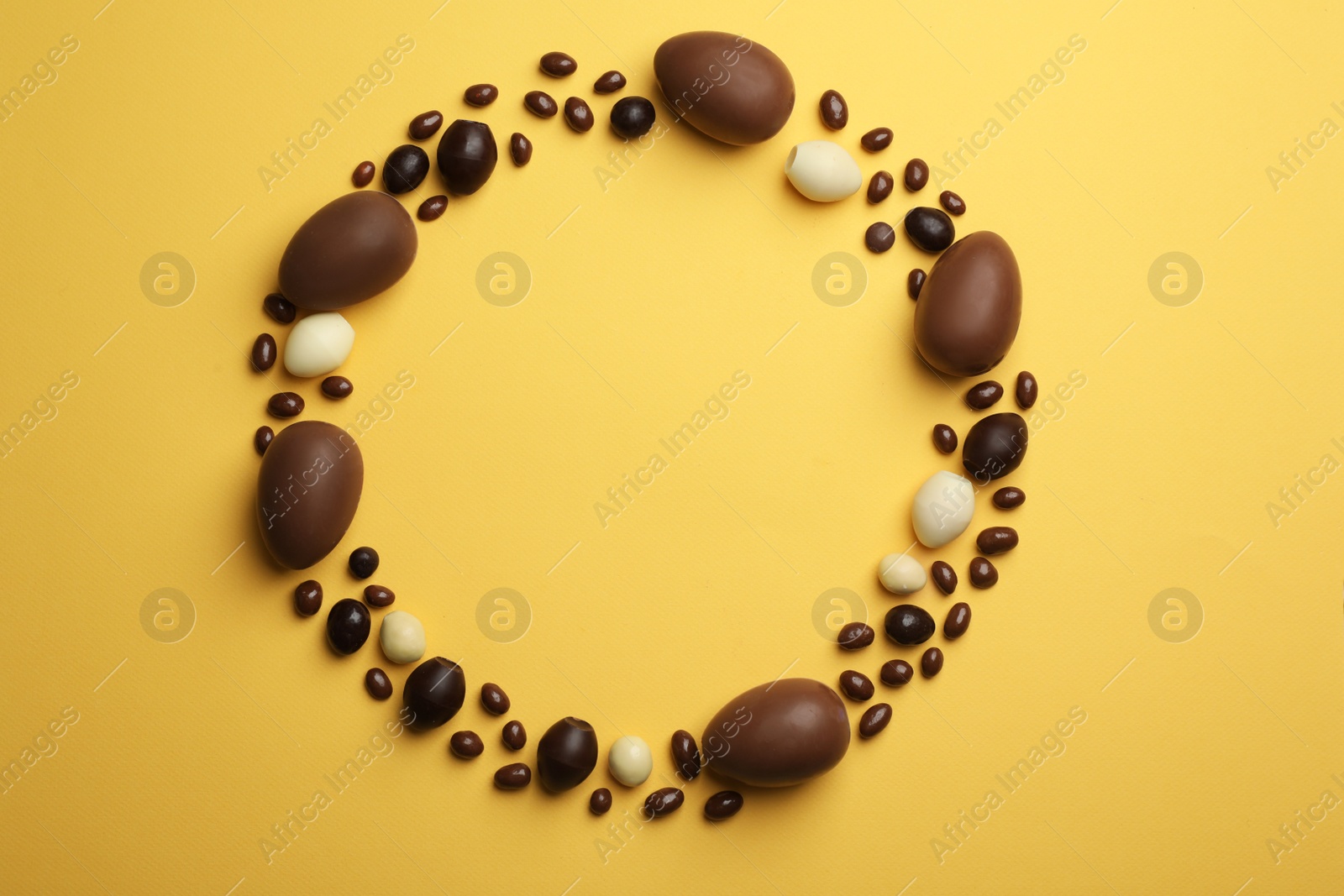 Photo of Flat lay composition with chocolate Easter eggs and space for text on color background