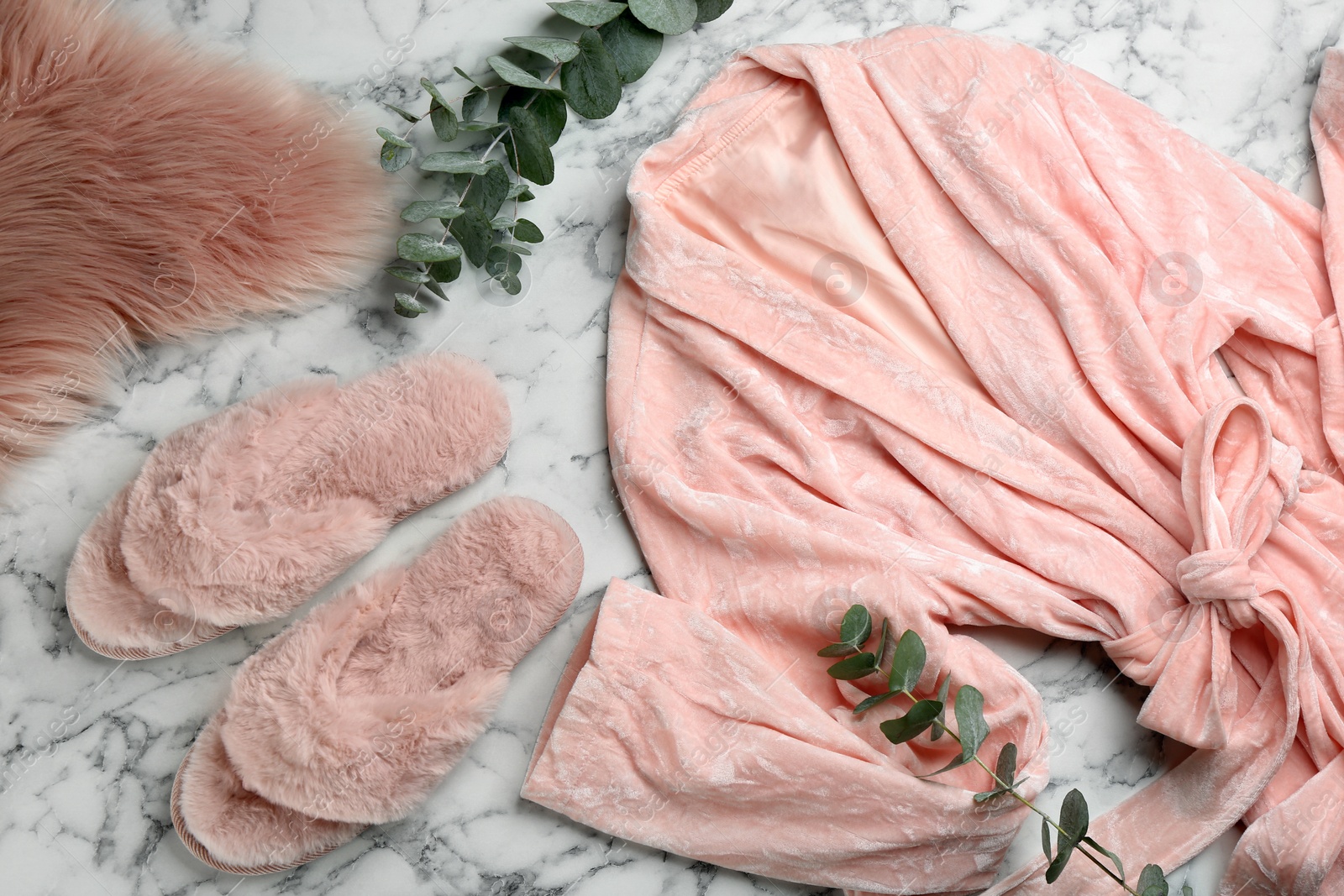 Photo of Flat lay composition with fluffy slippers and robe on white marble background. Comfortable home outfit