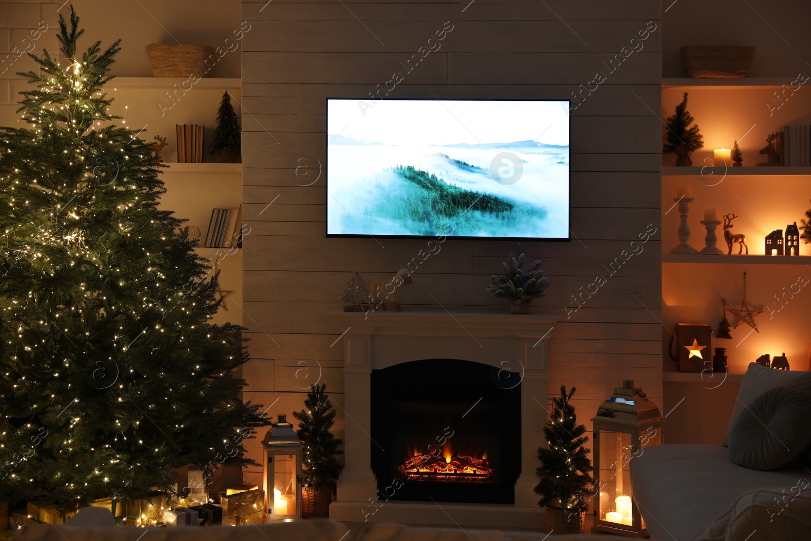 Photo of Stylish living room interior with TV set, Christmas tree and fireplace