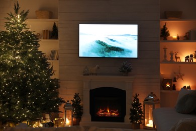 Photo of Stylish living room interior with TV set, Christmas tree and fireplace