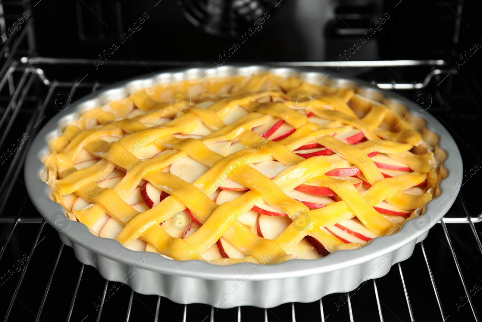 Photo of Traditional English apple pie on shelf of oven, closeup