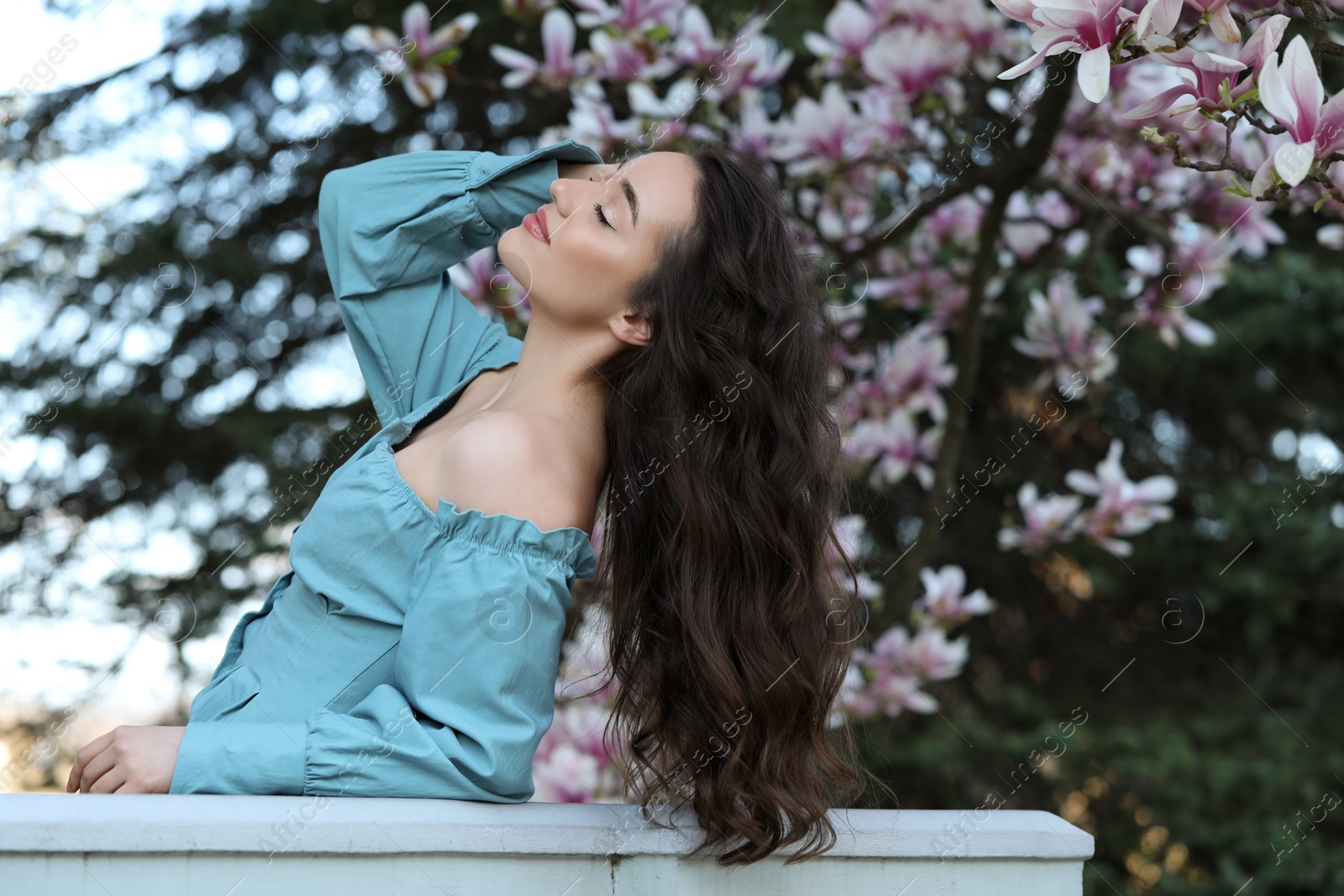 Photo of Beautiful woman near blossoming magnolia tree on spring day