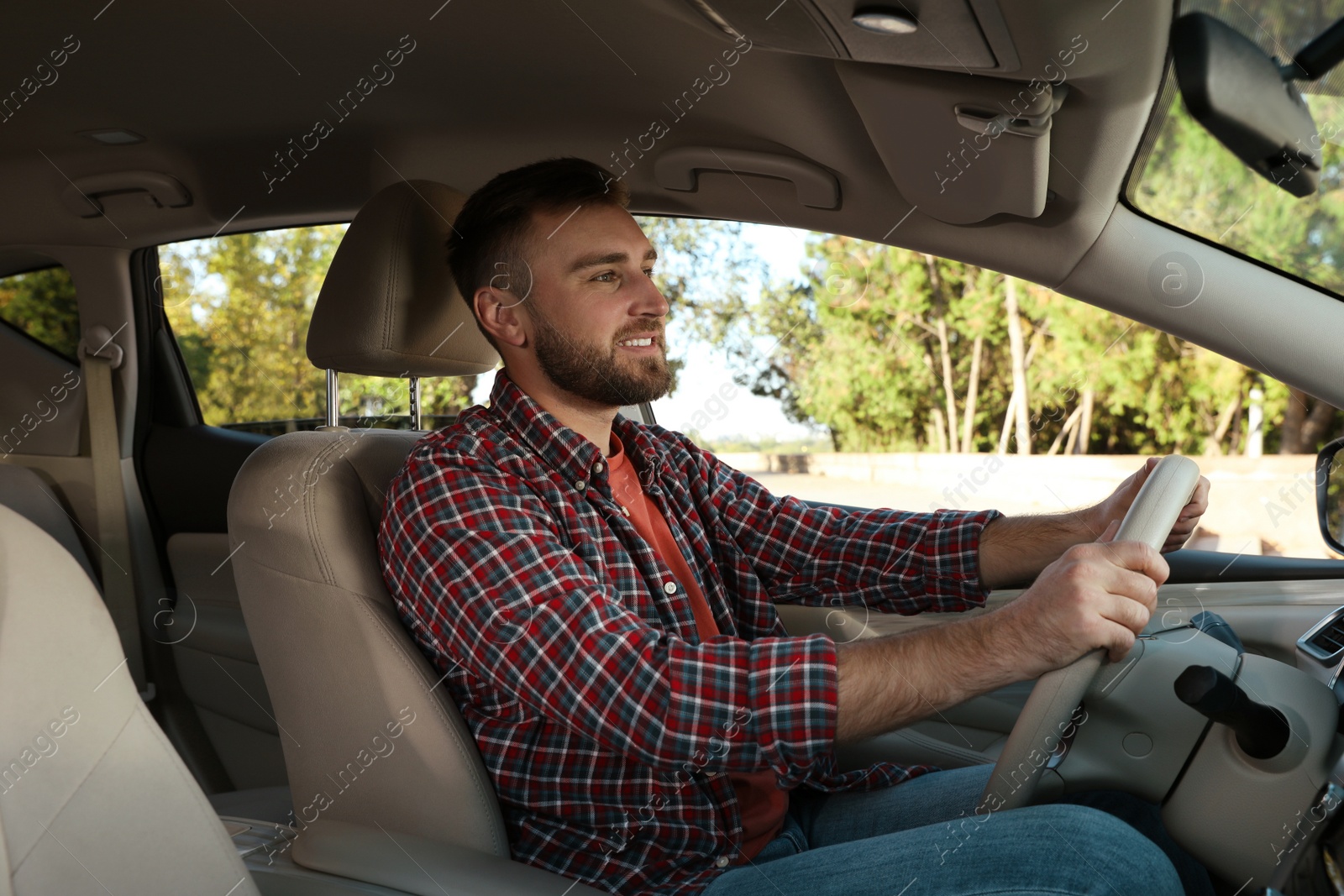 Photo of Handsome young driver sitting in modern car