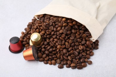 Bag with coffee capsules and beans on light grey table