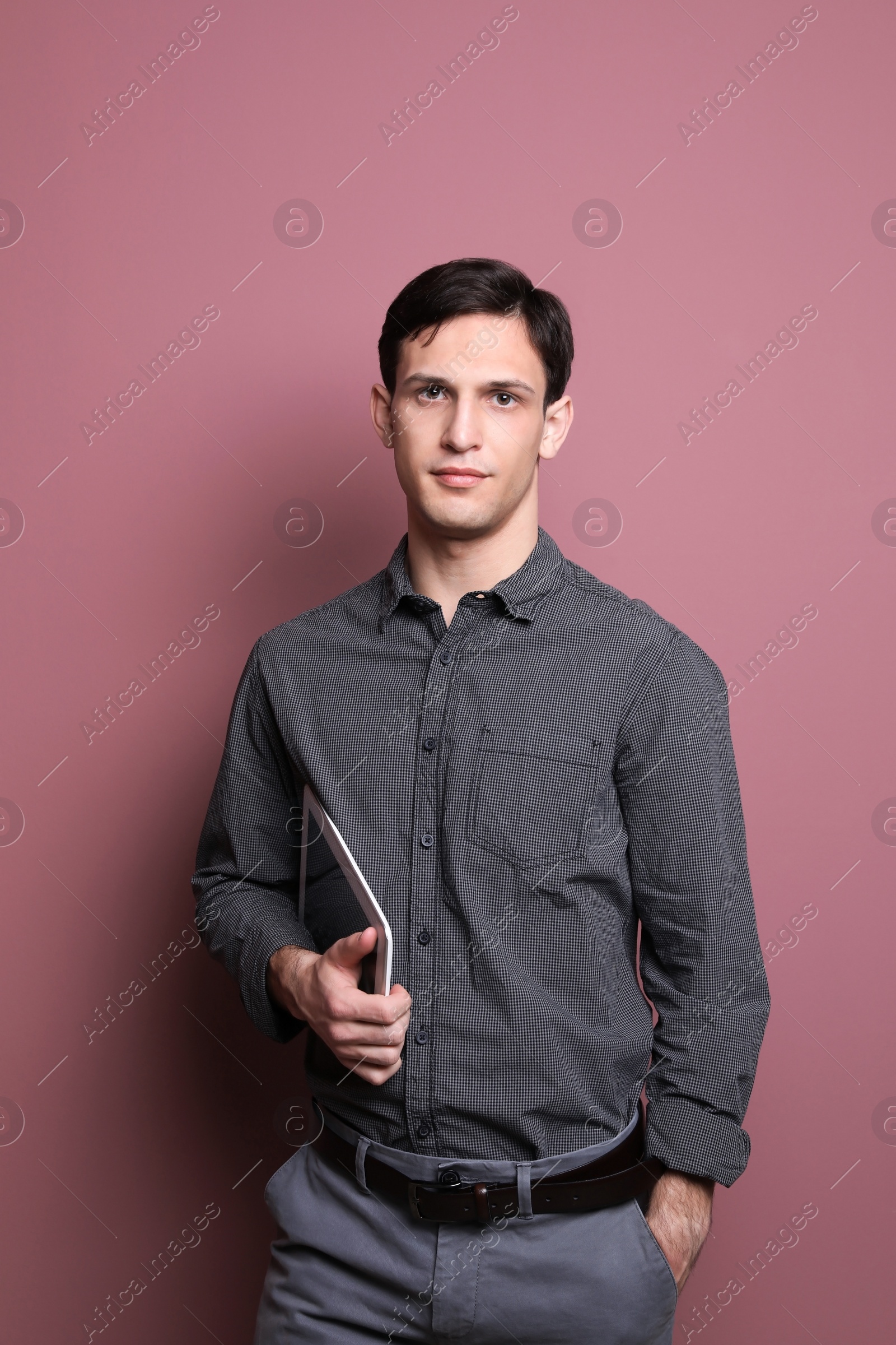 Photo of Portrait of confident young man with tablet on color background