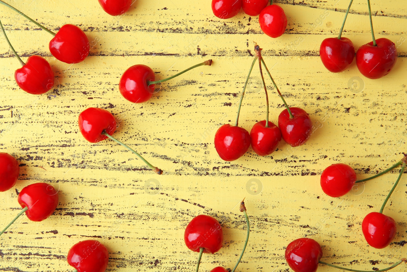 Photo of Ripe red cherries on wooden background, top view