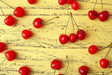 Ripe red cherries on wooden background, top view