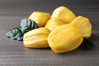 Photo of Delicious exotic jackfruit bulbs on wooden table