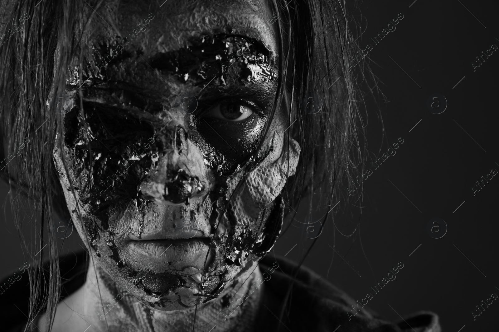 Photo of Scary zombie on dark background, black and white effect. Halloween monster