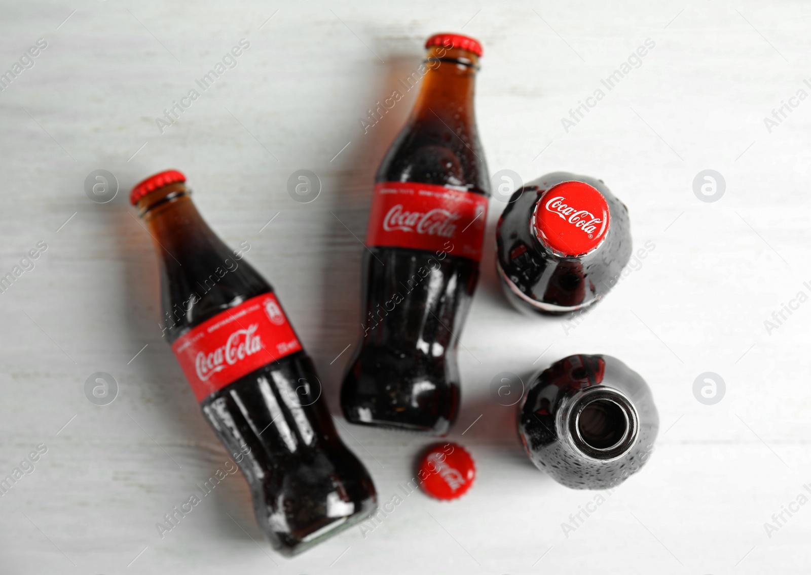 Photo of MYKOLAIV, UKRAINE - NOVEMBER 15, 2018: Bottles of Coca Cola on wooden background, top view