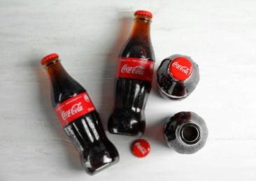 MYKOLAIV, UKRAINE - NOVEMBER 15, 2018: Bottles of Coca Cola on wooden background, top view