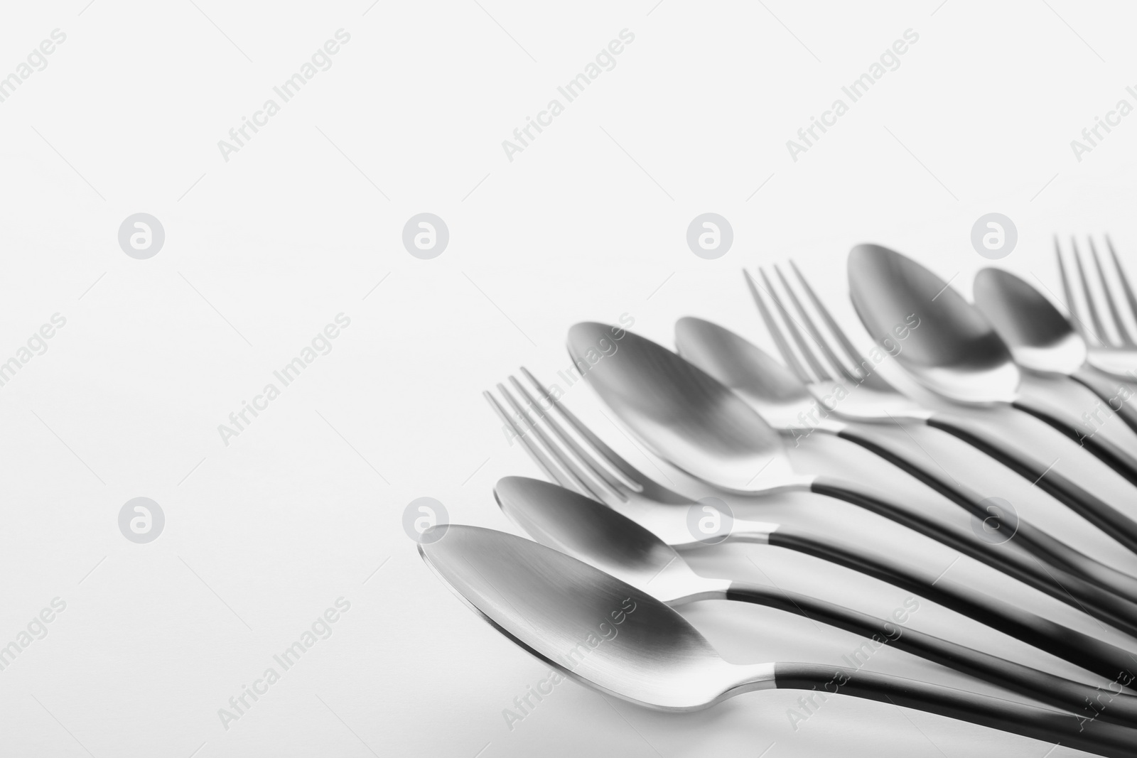 Photo of Forks and spoons on white background. New cutlery