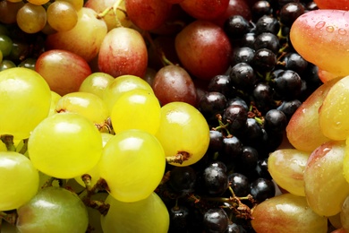 Photo of Fresh ripe juicy grapes with water drops as background, closeup