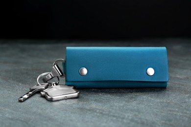Photo of Leather case with key on grey table, closeup