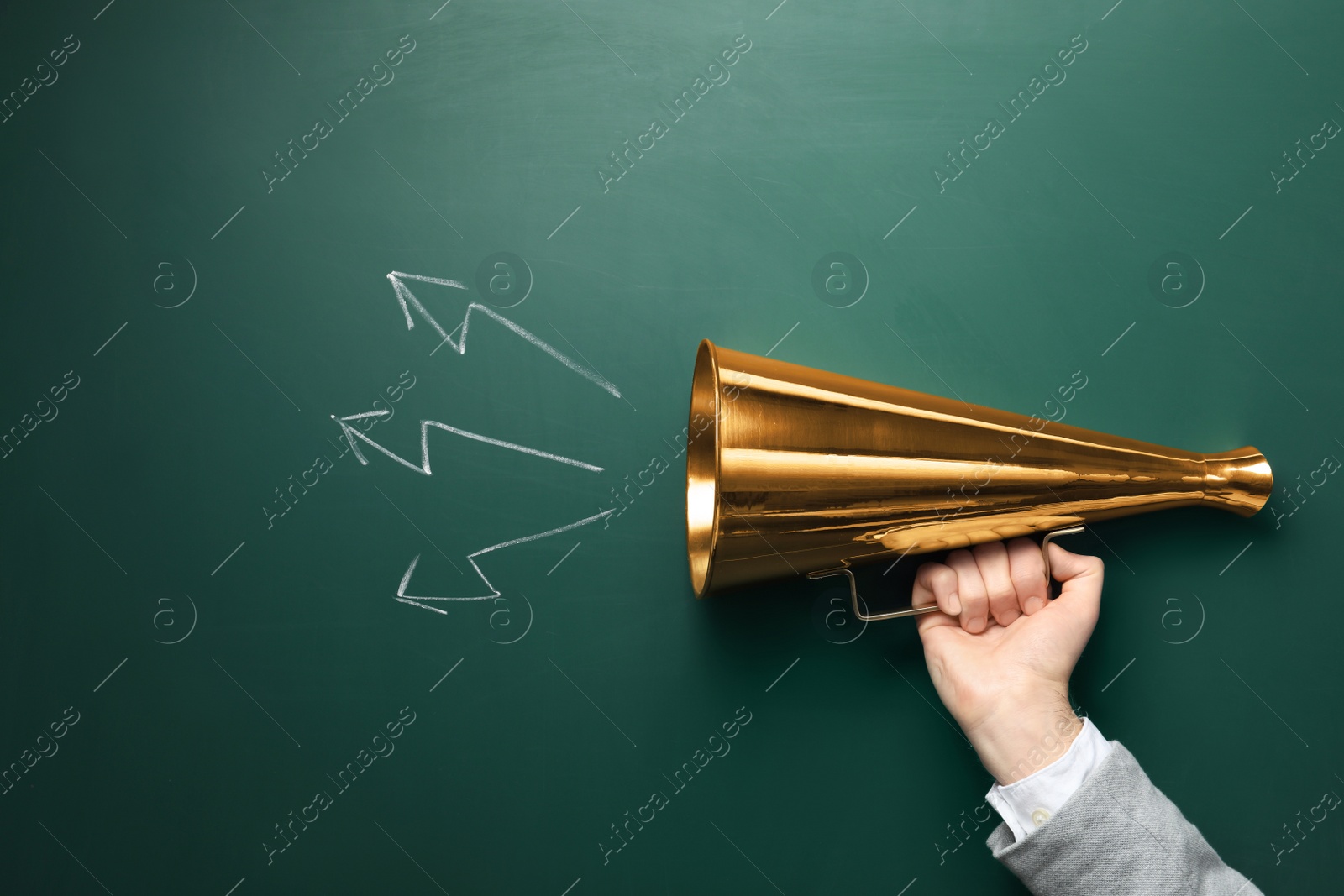 Photo of Man holding retro megaphone near chalkboard