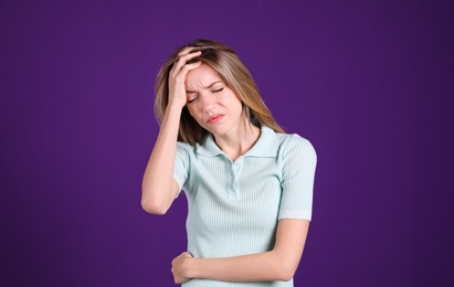 Photo of Portrait of stressed young woman on purple background