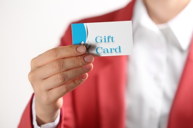 Woman holding gift card on white background, closeup