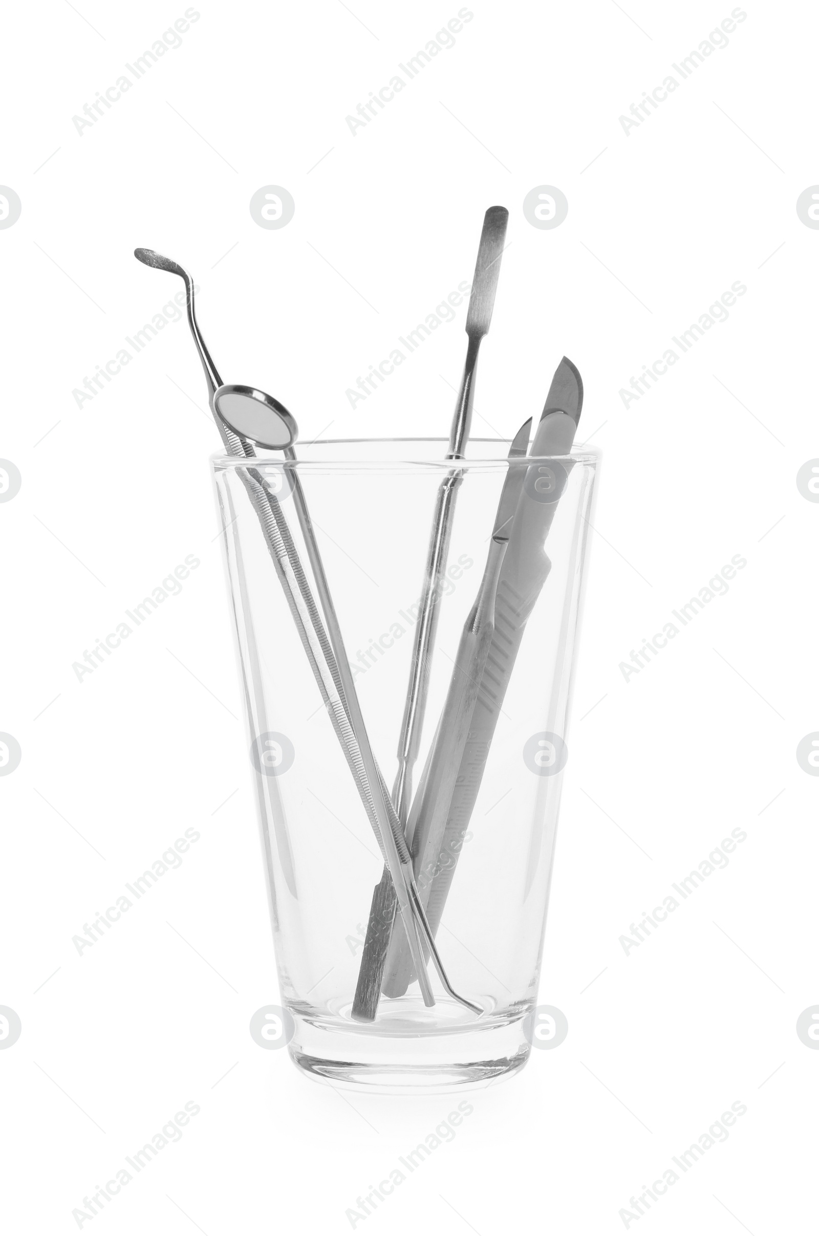 Photo of Glass holder with set of dentist's tools on white background