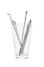 Photo of Glass holder with set of dentist's tools on white background