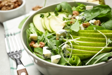 Photo of Tasty salad with pear slices in bowl, closeup