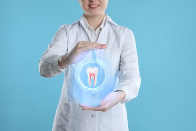 Image of Dentist showing virtual model of tooth on light blue background, closeup