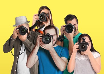 Image of Group of professional photographers with cameras on yellow background