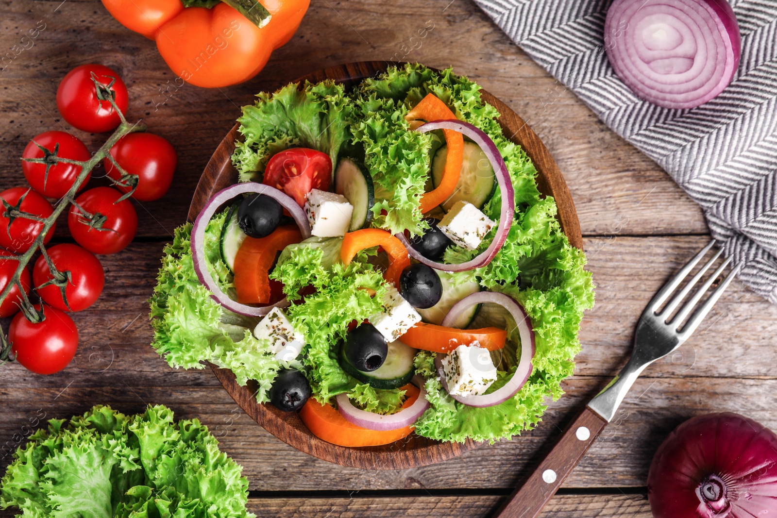 Photo of Tasty fresh Greek salad on wooden table, flat lay