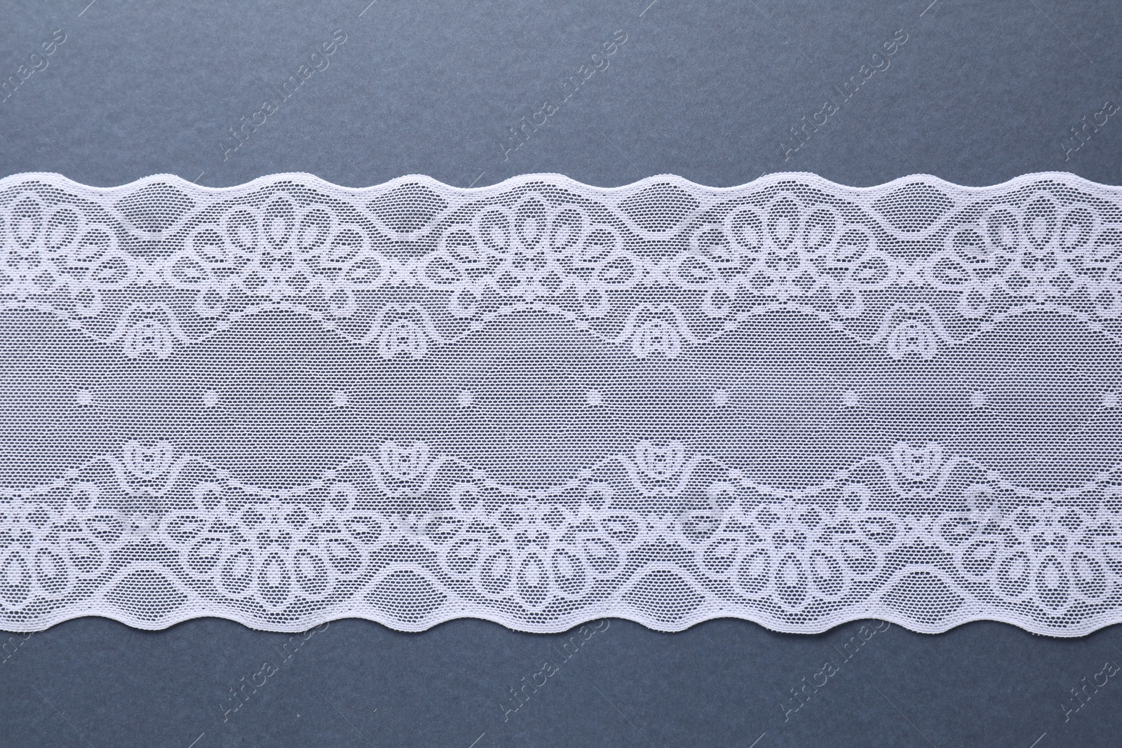 Photo of White lace on light blue background, top view