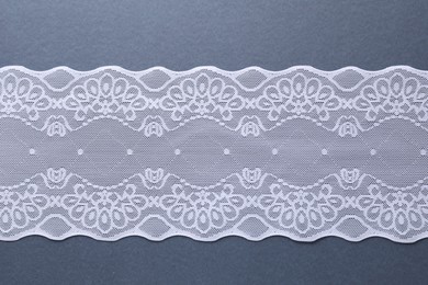 Photo of White lace on light blue background, top view