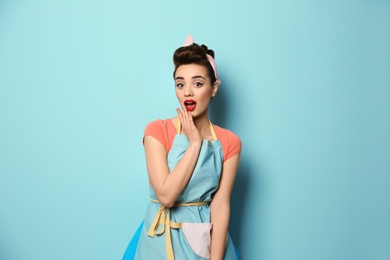 Photo of Portrait of funny young housewife on color background