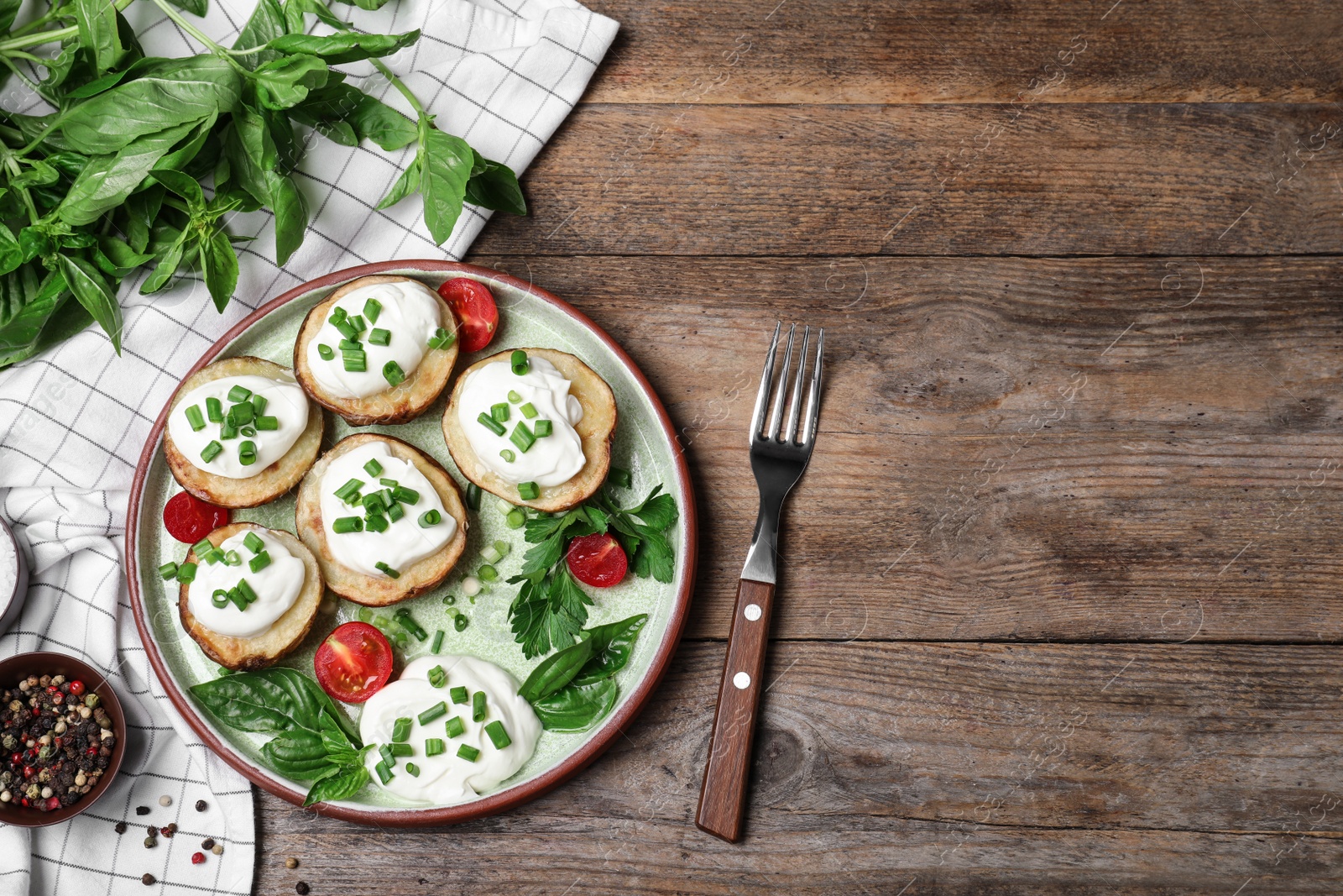 Photo of Delicious potato wedges with sour cream served on wooden table, flat lay. Space for text