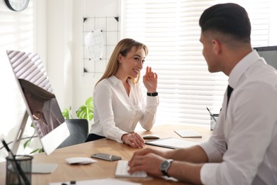 Young woman flirting with her colleague during work in office