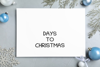 Flat lay composition of card with words Days To Christmas and space for text on light grey stone table. Holiday countdown