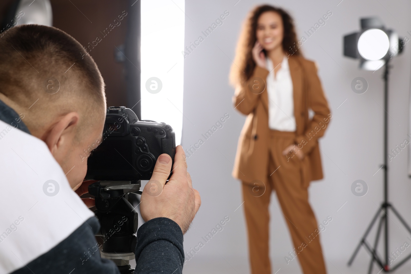 Photo of Beautiful African American model posing for professional photographer in studio, focus on camera