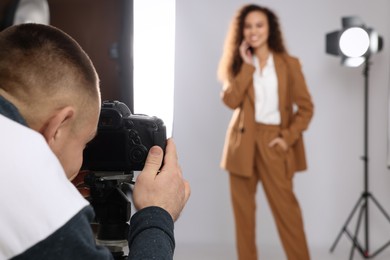 Beautiful African American model posing for professional photographer in studio, focus on camera