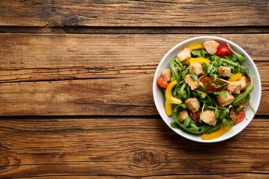 Delicious fresh chicken salad served on wooden table, top view. Space for text