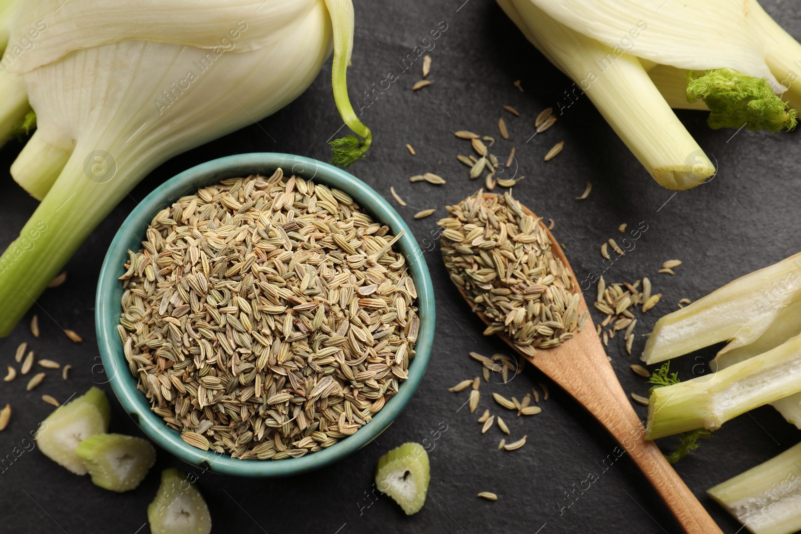 Photo of Fennel seeds in bowl, whole and cut vegetables on gray table, flat lay