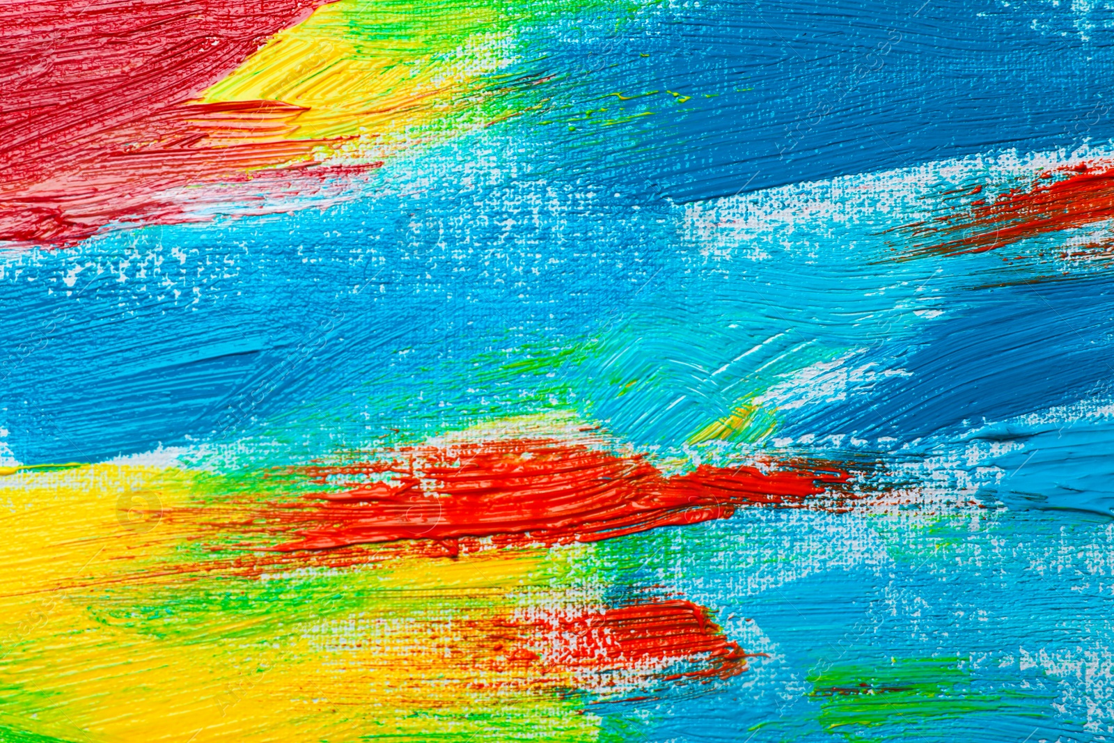 Photo of Strokes of colorful acrylic paints on canvas, closeup