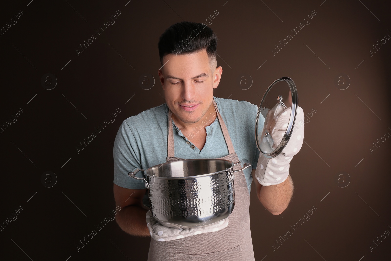 Photo of Handsome man with pot on brown background