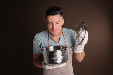 Handsome man with pot on brown background