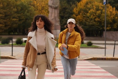 Being late. Women running on pedestrian crossing outdoors