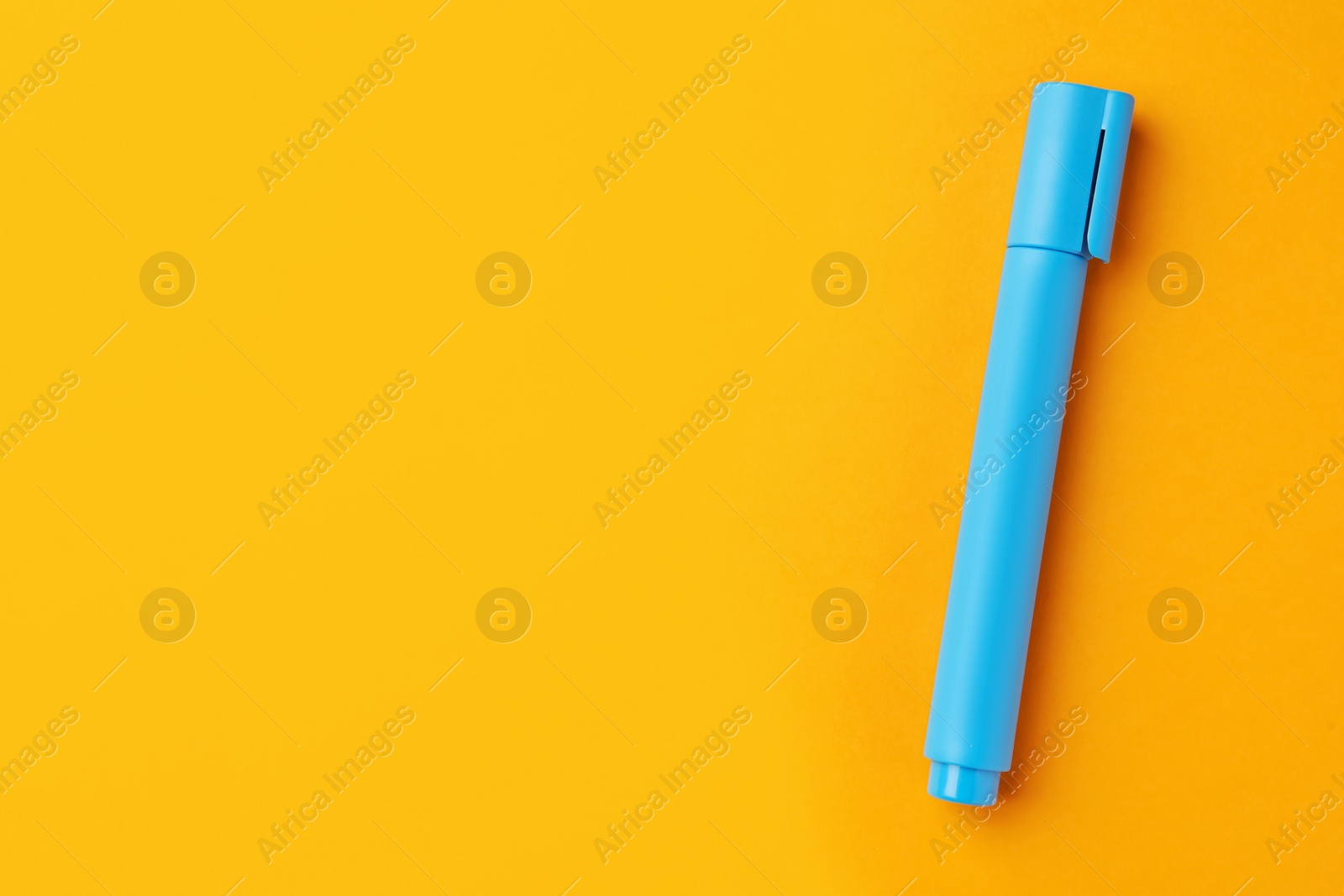 Photo of Bright light blue marker on orange background, top view. Space for text