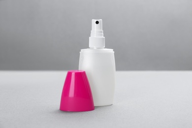 Photo of Bottle with insect repellent spray on grey background