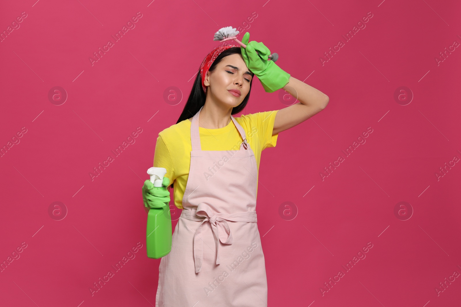 Photo of Young housewife with detergent and brush on pink background