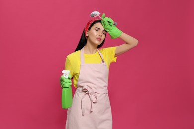 Photo of Young housewife with detergent and brush on pink background