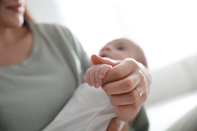 Photo of Young woman with her cute baby on blurred background, closeup