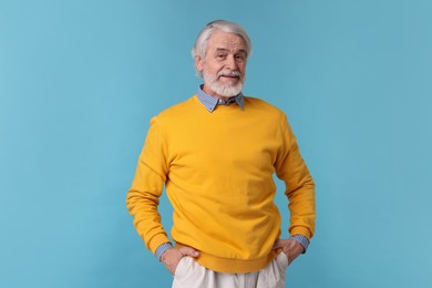 Photo of Portrait of stylish grandpa on light blue background