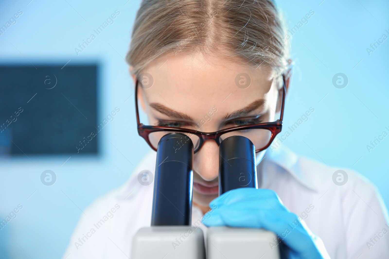 Photo of Female scientist using modern microscope in chemistry laboratory