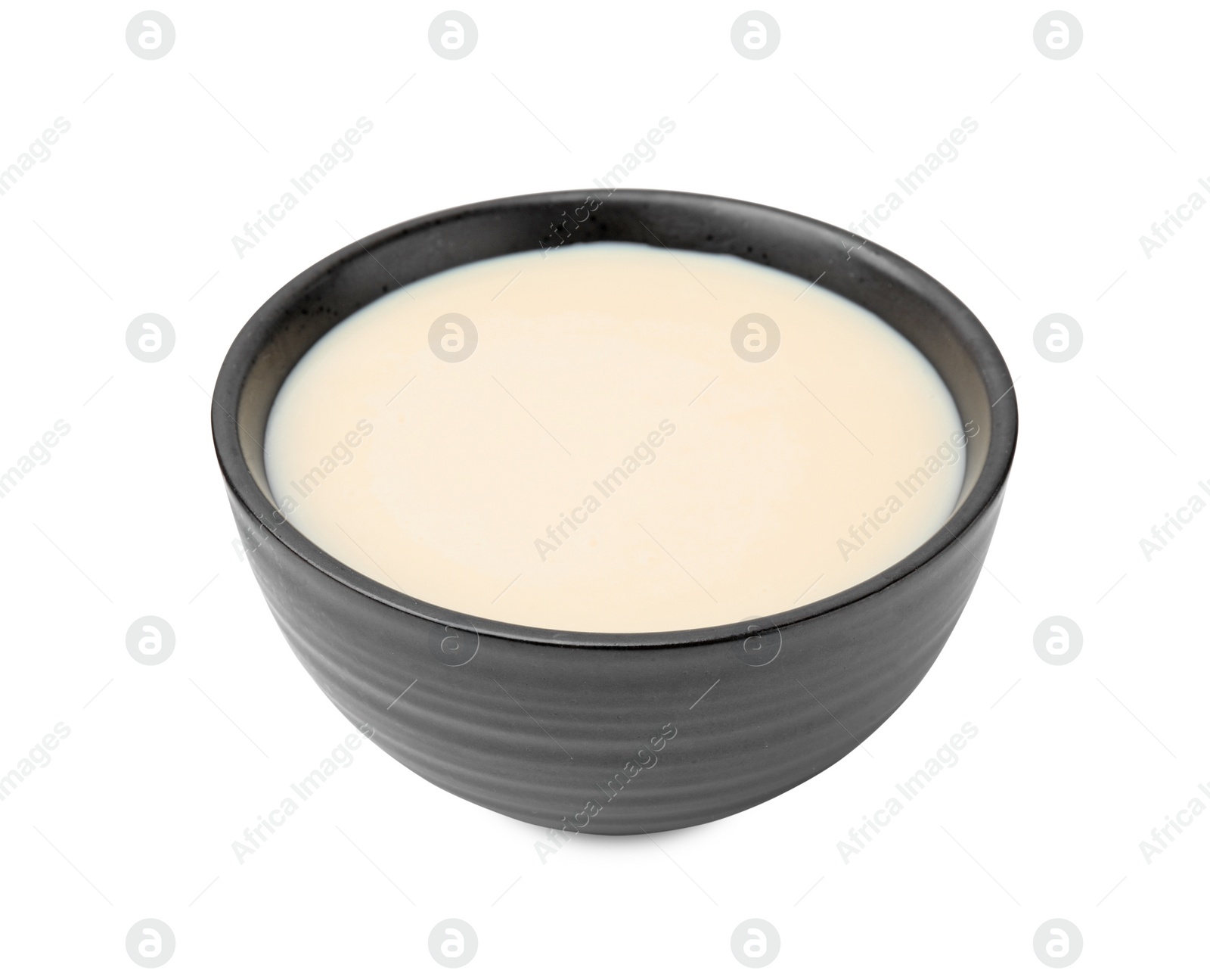 Photo of Bowl with condensed milk isolated on white